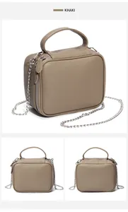Détail du sac à main en cuir kaki avec texture litchi et bandoulière chaîne argentée