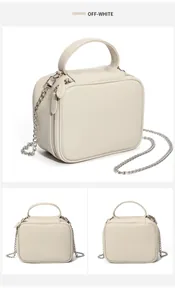 Détail du sac à main en cuir beige avec double fermeture éclair et bandoulière