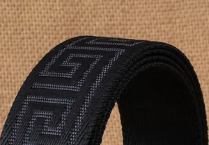 Detail eines schwarzen Nylon-Taktikgürtels mit gewebtem Mäandermuster auf grobem Leinenhintergrund