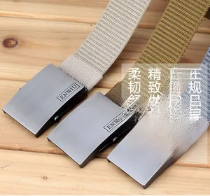 Detail of three heavy-duty nylon belts with matte metal buckle on wooden surface