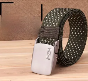 Detail of army green nylon belt with white speckled pattern and engraved metal buckle
