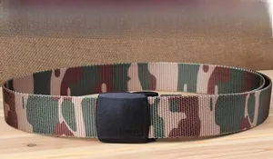 Close-up of camouflage nylon tactical belt with a smooth black plastic buckle on wood