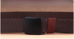 Close-up of a striped nylon woven belt with a matte black YKK buckle and ENNIU branding