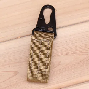 Detail of khaki nylon webbing and black metal eagle beak tactical hook on wood background