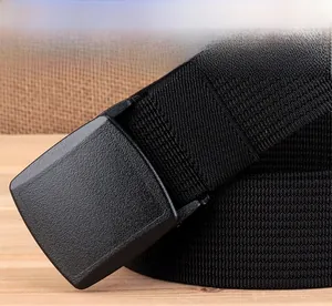 Close-up of black nylon woven belt with a matte plastic buckle on a rustic wooden table