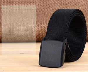 Close-up of a rolled black nylon tactical belt with a matte YKK buckle on a wooden desk