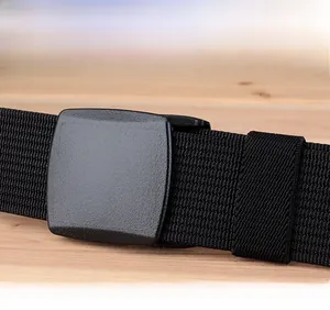 Close-up of black nylon belt with matte YKK plastic buckle on a wooden surface