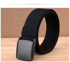 Detail view of black lightweight nylon belt with plastic buckle on a wood background