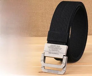 Détail de la boucle double D en métal brossé sur une ceinture en nylon noir tressé