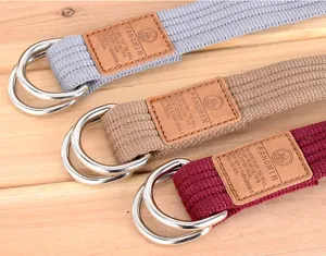 Détail de ceintures en toile tressée grise et marron avec boucles doubles anneaux D