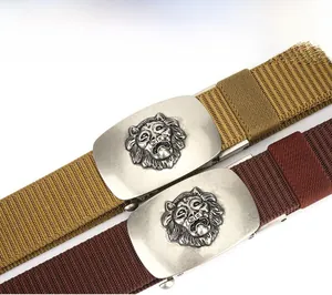 Detailed macro of woven canvas belts featuring lion head embossed metal buckles