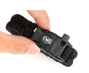 Detail of parcord bracelet buckle with integrated compass, whistle, and flint for survival