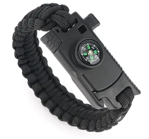 Detail of a tactical survival bracelet featuring woven black paracord and a mini compass