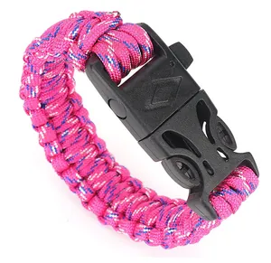 Dettaglio del braccialetto survival in paracord rosa intrecciata con fibbia a fischietto