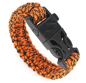 Dettaglio del braccialetto di sopravvivenza in paracord intrecciato arancione e nero con fibbia