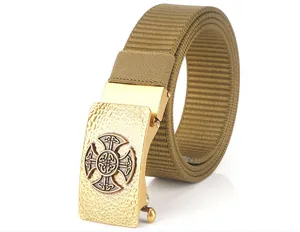 Detail of khaki nylon belt with textured golden metal buckle and cross relief pattern