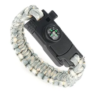 Tactical survival paracord bracelet with compass and emergency whistle on white background