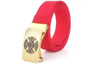 Close-up of red nylon belt with golden metal buckle featuring a celtic cross relief