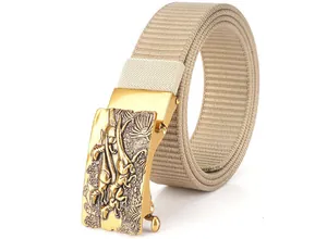 Close-up of golden automatic belt buckle with dinosaur relief on khaki nylon strap