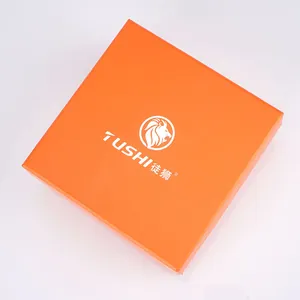 Leuchtend orangefarbene quadratische Geschenkbox mit TUSHI-Logo und matter Textur