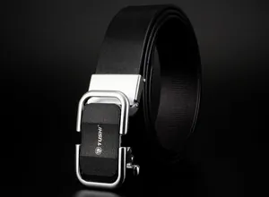Gros plan sur la ceinture en cuir noir avec boucle automatique argentée et insert texturé