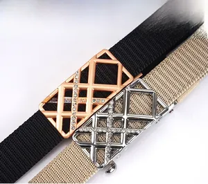 Nahaufnahme von geflochtenen Gürteln mit strassbesetzten geometrischen Metallschnallen