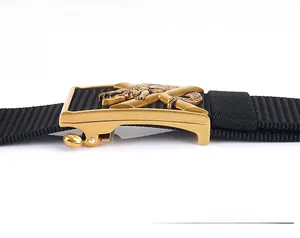 Vue macro de la boucle en métal doré avec relief crocodile sur ceinture en nylon noir épais