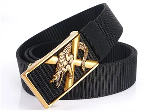 Détail d'une ceinture en nylon tressé noir avec boucle automatique dorée et relief crocodile
