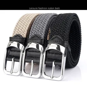 Close-up of khaki, grey, and black woven nylon belts with metal pin buckles and logo details