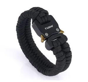 Detail of black paracord survival bracelet with TUSHI metal buckle and fiber texture