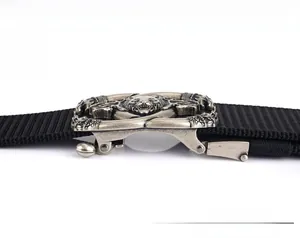 Detail of the tactical nylon belt showing the silver wolf head relief on metal buckle