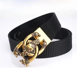 Close-up of golden metal belt buckle with wolf totem and thick black nylon webbing