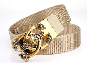 Macro shot of khaki nylon webbing belt with gold wolf head relief buckle detail