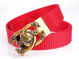 Detail of red tactical nylon belt featuring a large gold alloy buckle with wolf head relief