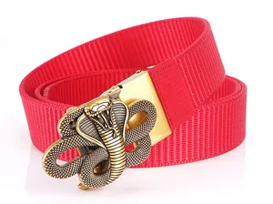 Detail of red nylon belt featuring a 3D gold cobra buckle with embossed metallic texture