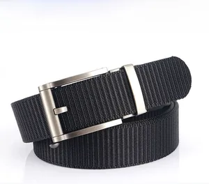 Détail de la texture de ceinture en nylon noir et boucle automatique en métal brossé
