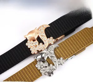 Close-up of sparkling fox buckles with white rhinestones on woven nylon waist belts