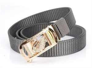 Macro detail of grey nylon belt with golden automatic buckle featuring a swan emblem