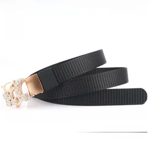 Detail of black nylon web belt featuring a gold fox buckle with inlaid rhinestones