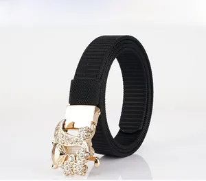 Detail of black nylon belt featuring a gold floral buckle set with sparkling rhinestones