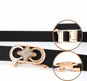 Détail de boucle dorée infini sertie de cristaux sur ceinture noire en nylon