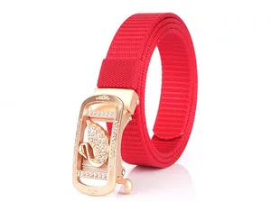 Detail of red nylon woven belt with rose gold automatic buckle and swan logo motif