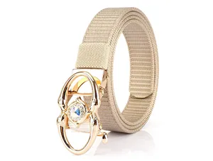 Macro detail of khaki woven belt strap with gold buckle and iridescent gemstone