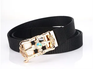 Close-up of black elastic belt with vintage gold buckle featuring crystals and gemstone