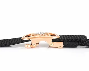 Détail d'une ceinture en nylon noir avec boucle en alliage doré et strass blancs