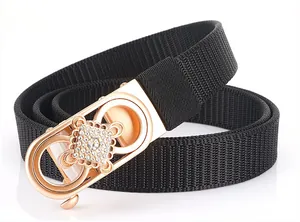 Detail of black nylon woven belt with rose gold rhinestone buckle and diamond pattern