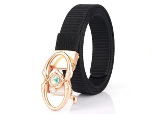 Close-up of golden dolphin buckle with crystal inlay on a black woven nylon belt