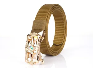 Detail view of khaki nylon belt featuring a gold floral buckle with iridescent gemstone