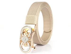 Detailed view of beige nylon belt with golden buckle featuring a diamond-studded center