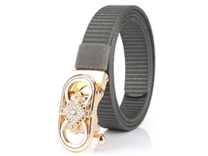 Detail of grey nylon belt featuring a gold automatic buckle with sparkling white rhinestones